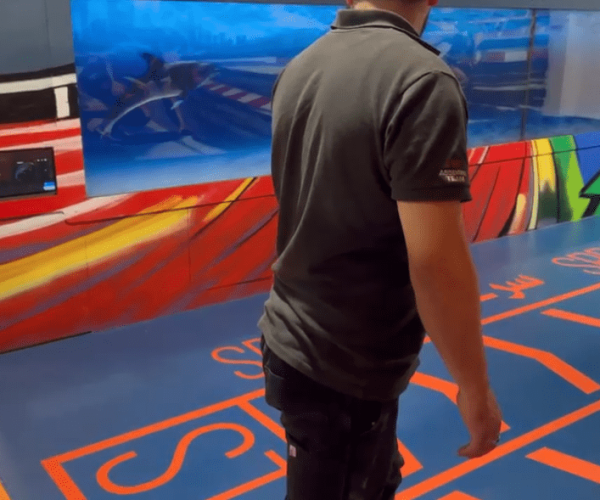Visitor racing a digital opponent along the Olympic Sprint video wall